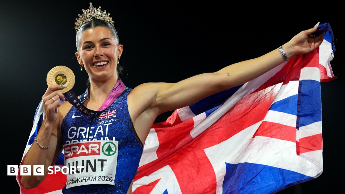 A female athlete wearing a crown and medal holds a gold medal and a Union Jack flag.