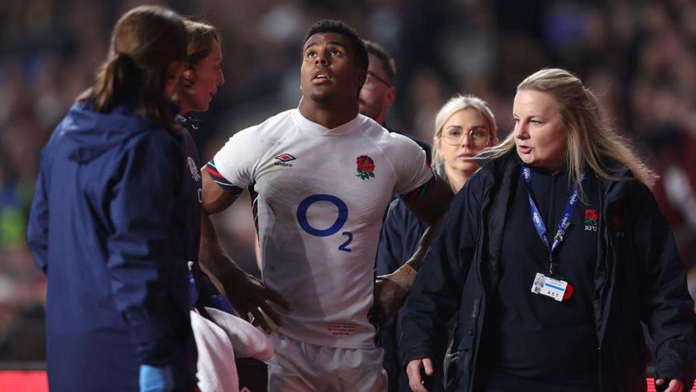 England's Immanuel Feyi-Waboso looks upwards as he's treated by medics