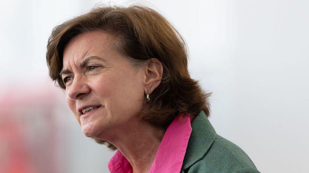 A head and shoulders photograph image of Eluned Morgan looking out of shot. The background is blurred.