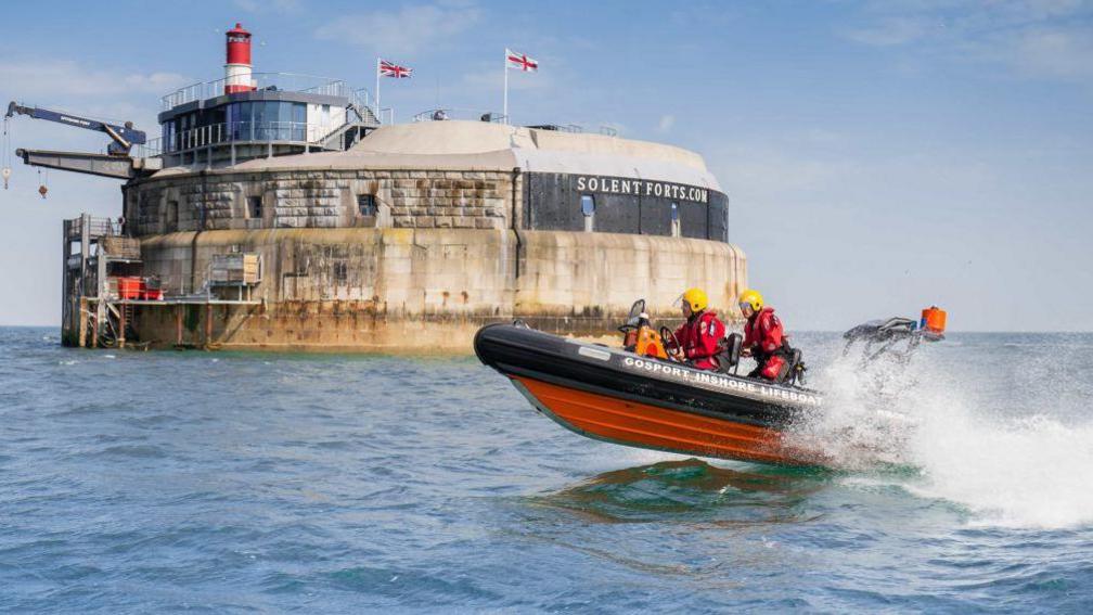 A two-man lifeboat speeds past one of the historic forts in the Solent.