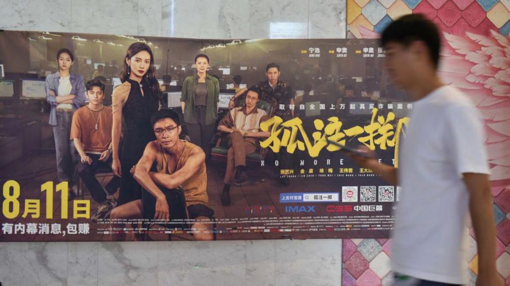 A viewer walks by a poster of movie "No More Bets" 