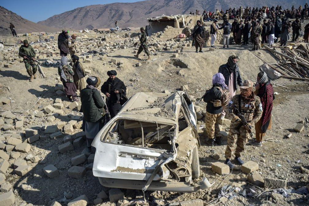 Taliban security personnel inspect a damaged car two days after air strikes by Pakistan in the Barmal district of eastern Paktika province on December 26, 2024. Pakistan air strikes in an eastern border region of Afghanistan killed 46 civilians, the Taliban government said on December 25, whilst a Pakistan security official said the bombardment had targeted "terrorist hideouts".