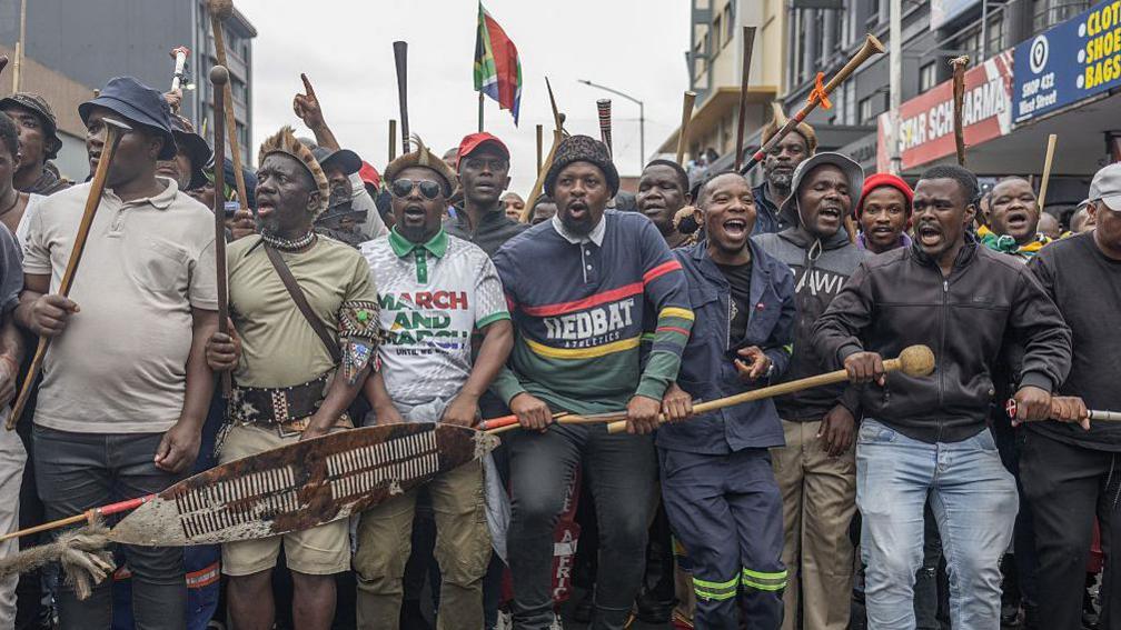 Members of the Zulu regiment known as the 'Amabutho' holding sticks march during a demonstration 