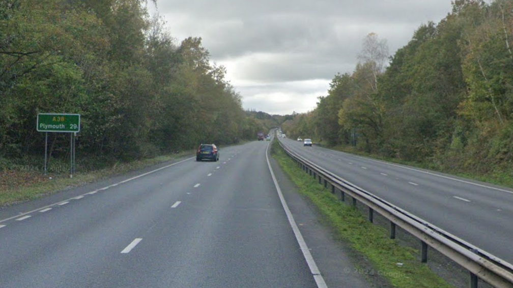 Google image shows the A38 heading toward Plymouth. Cars are travelling on both sides of the dual carriageway. A central reservation separates the two carriages. Trees line the dual carriageway. A sign which states A38 Plymouth 29 is on the left hand side. 