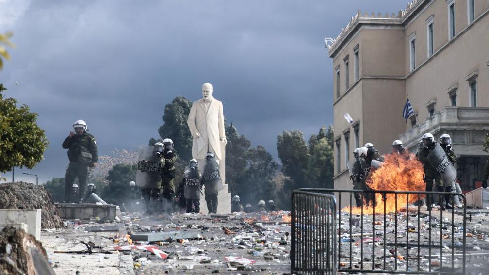 Police in riot gear stand in the centre of Athens