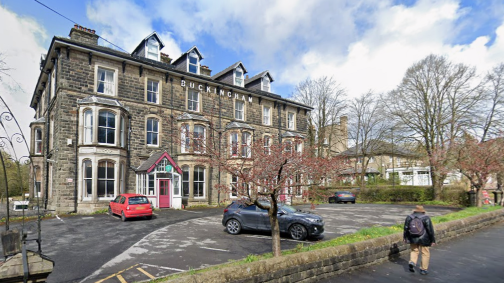 Three-storey brick building with a car park in front of the hotel
