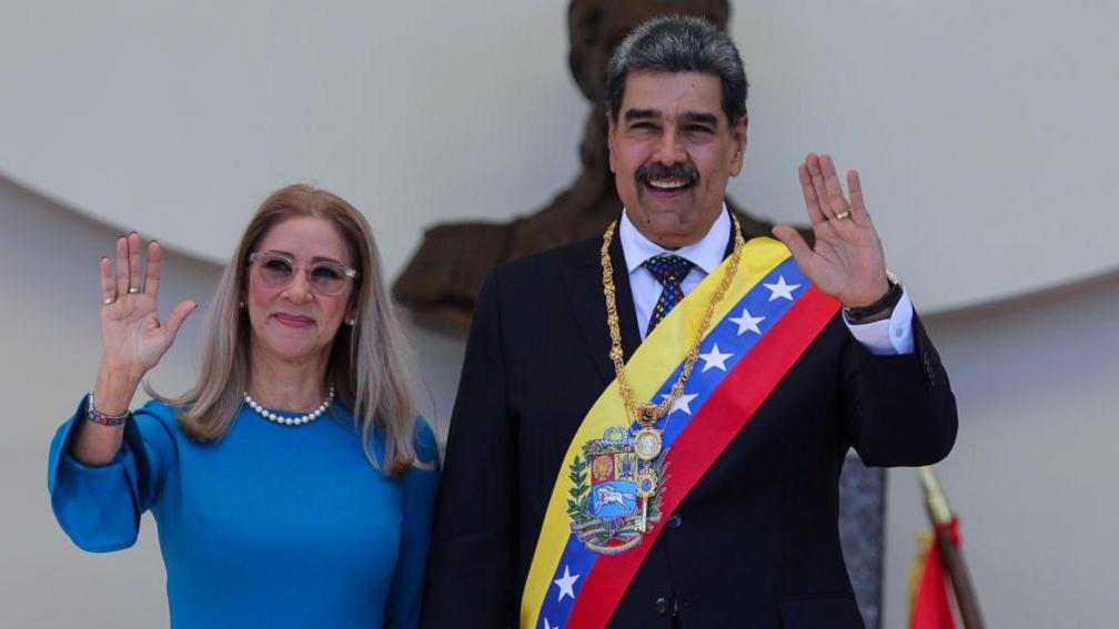 Flores and Maduro waving to a crowd