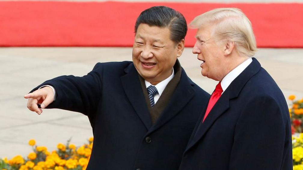 Chinese President Xi Jinping is smiling and pointing at something while talking to US President Donald Trump at a welcoming ceremony in November 9, 2017 in Beijing, China.