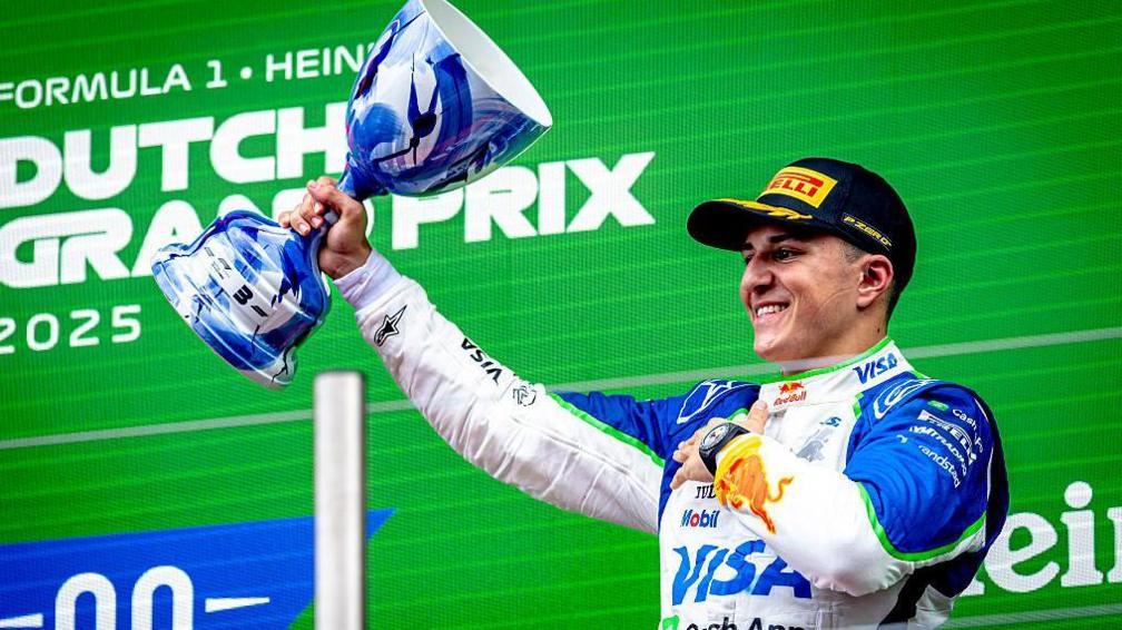 Isack lifts his trophy on the podium after finishing third in the Dutch Grand Prix