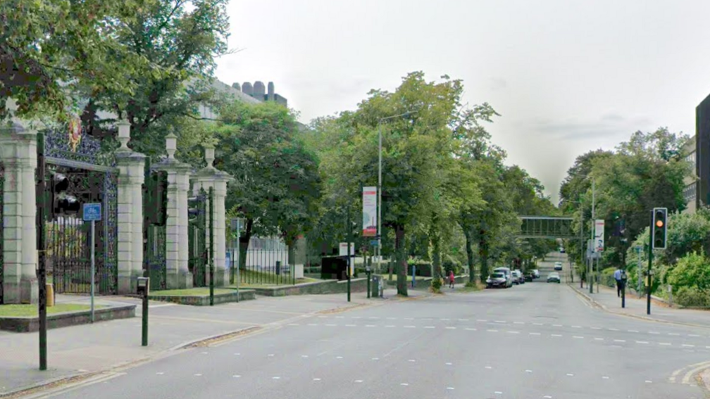 University Road in Leicester with ornate iron gates to Victoria Park on the left of the image