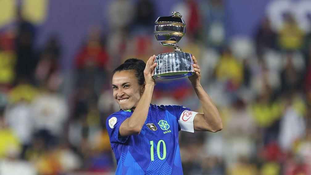 Marta holds up the Women's Copa America player of the tournament trophy