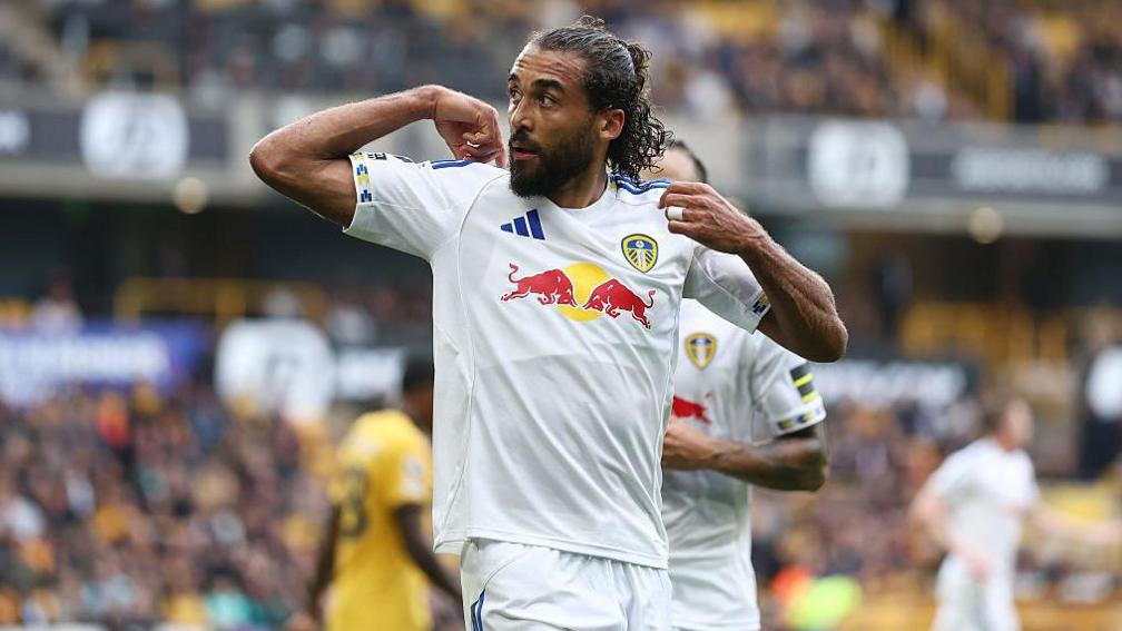 Dominic Calvert-Lewin points to the back of his shirt after drawing Leeds level against Wolves