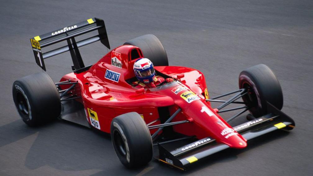 A close-up image of Alain Prost driving the Ferrari 641 during the 1990 Italian Grand Prix at Monza
