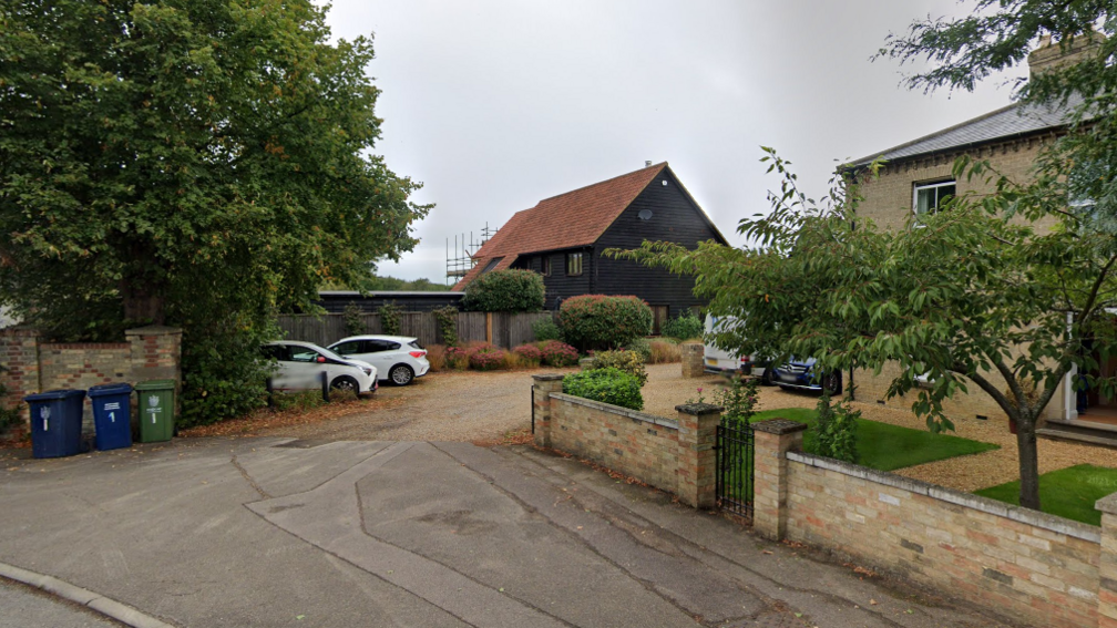 Primes Corner in Histon showing a yellow stone house, a gravel driveway and a barn-style house in the background