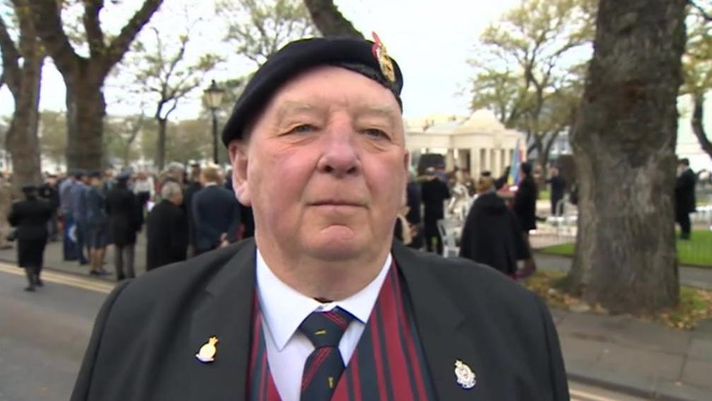 A man in a black beret and suit 