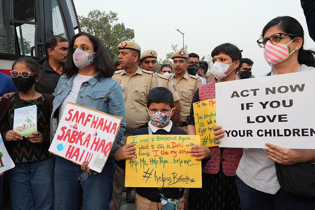 Women and children hold placards to protest against the hazardous air pollution situation in New Delhi, India, on November 9, 2025. (Photo by Bilal Kuchay/NurPhoto via Getty Images)
