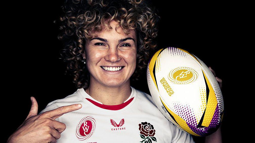 Ellie Kildunne points to a rugby ball