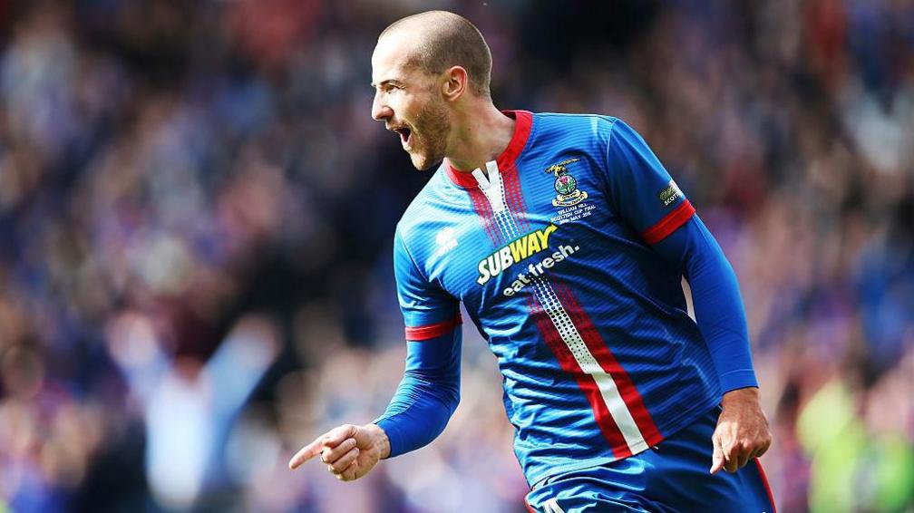 Inverness player James Vincent celebrates scoring a goal in 2015's Scottish Cup final. He points to the ground while cheering.