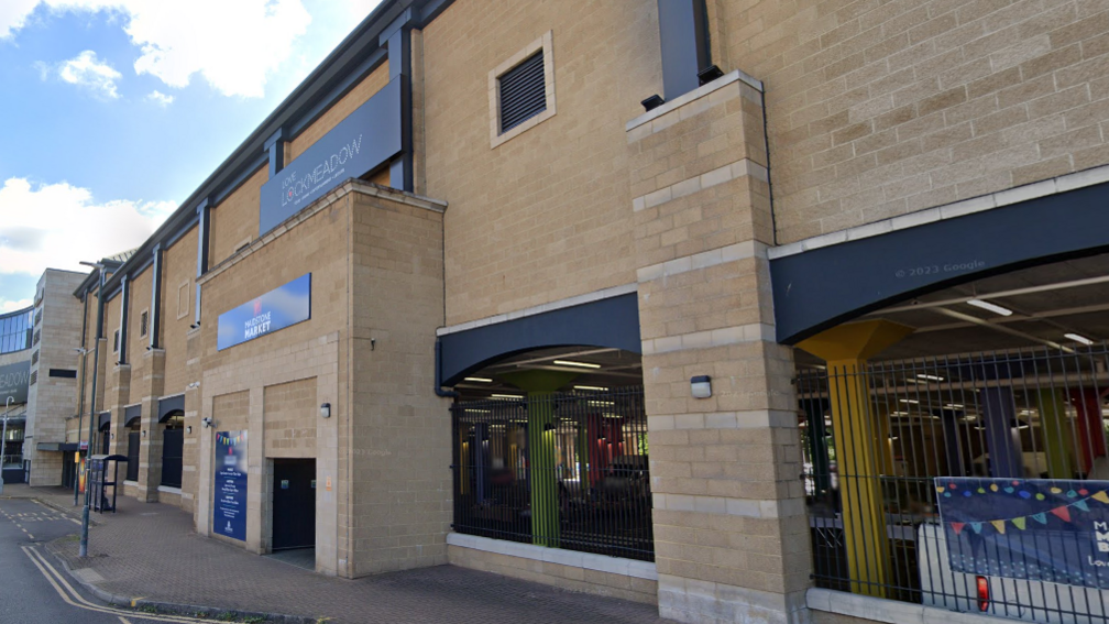 A google street view image of Lockmeadow leisure complex, which is a sandstone structure with a ground floor car park behind black railings