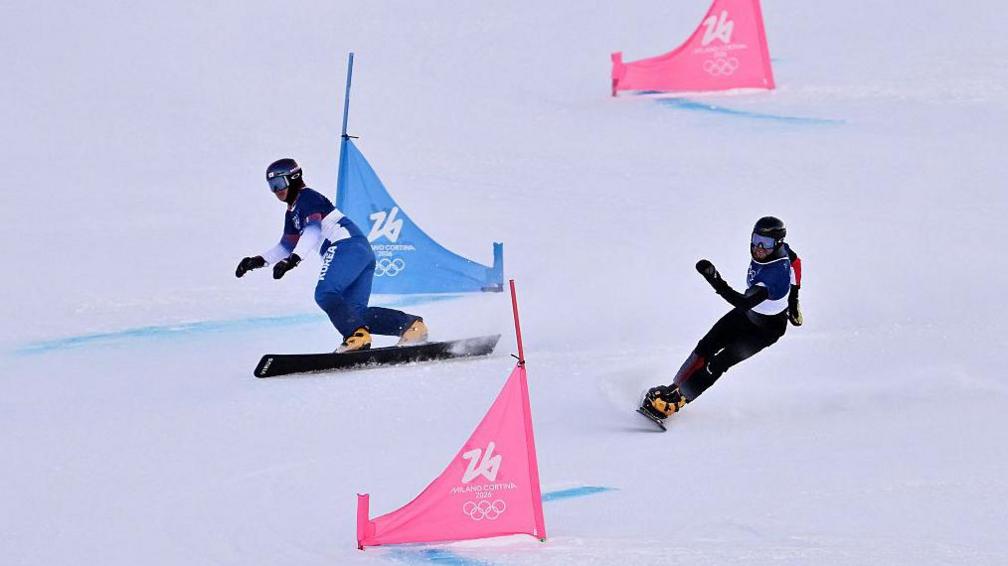 South Korea's Kim Sangkyum and Austria's Andreas Prommegger compete in the snowboard men's parallel giant slalom qualification run during the Milan-Cortina 2026 Winter Olympics