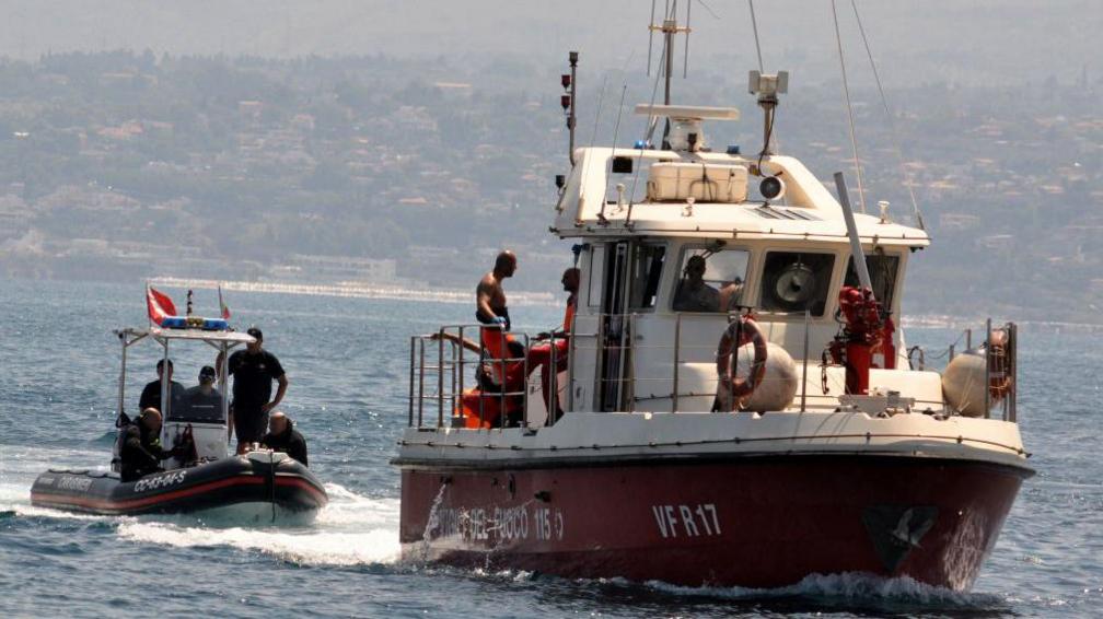 Divers of the Vigili del Fuoco, the Italian Corps of Firefighters, enter Porticello harbor near Palermo, with the body of Hannah Lynch, the last missing person, at the back of the boat on 23 August 2024