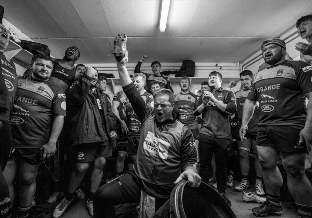 players in a rugby changing room, celebrating