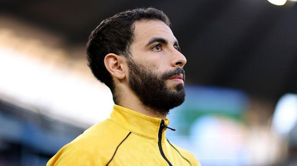 Rayan Ait-Nouri looks upwards while wearing a Wolves tracksuit top