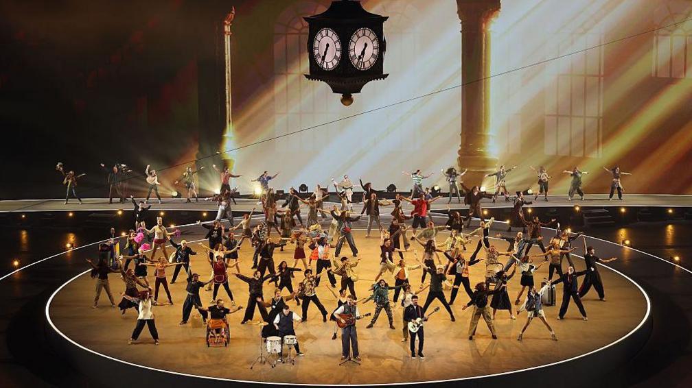 Theatrical performance under a likeness of the Glasgow Central Station clock 