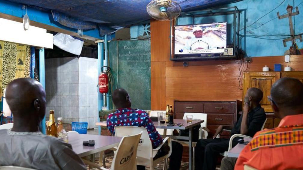 People watching a TV in Mali in 2018.