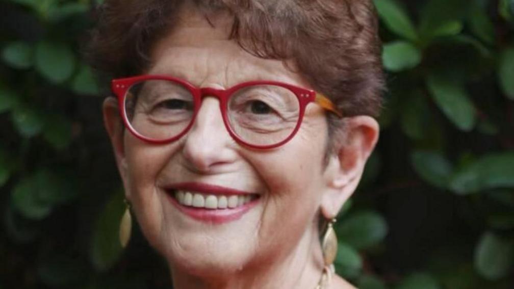 Professor of psychology Felicia Huppert wearing red-framed glasses