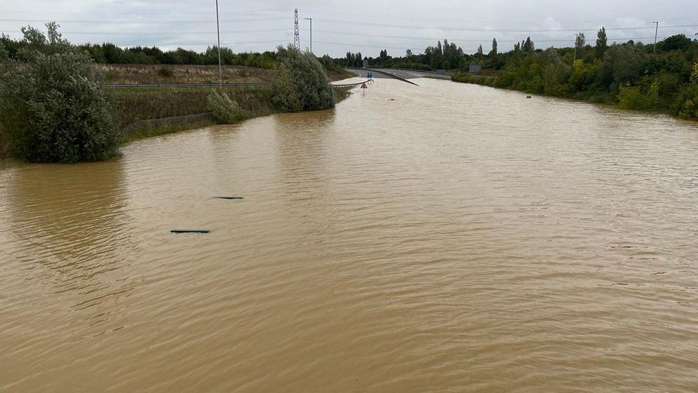 The top of the Lower Shelton pumping station can be seen on the left, submerged in floodwater on the A421 near the bridge that carries Beancroft Road