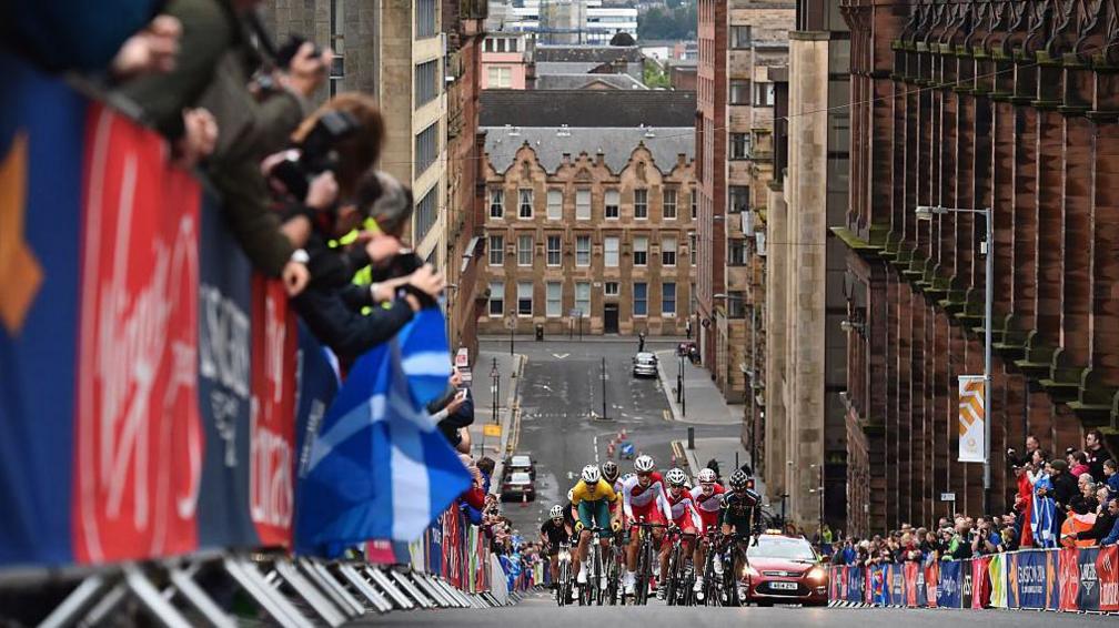 A road race, with cyclists going uphill on a Glasgow street