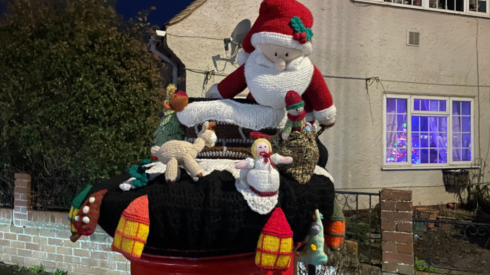 Postbox topper with nativity scene and Santa in its centre.