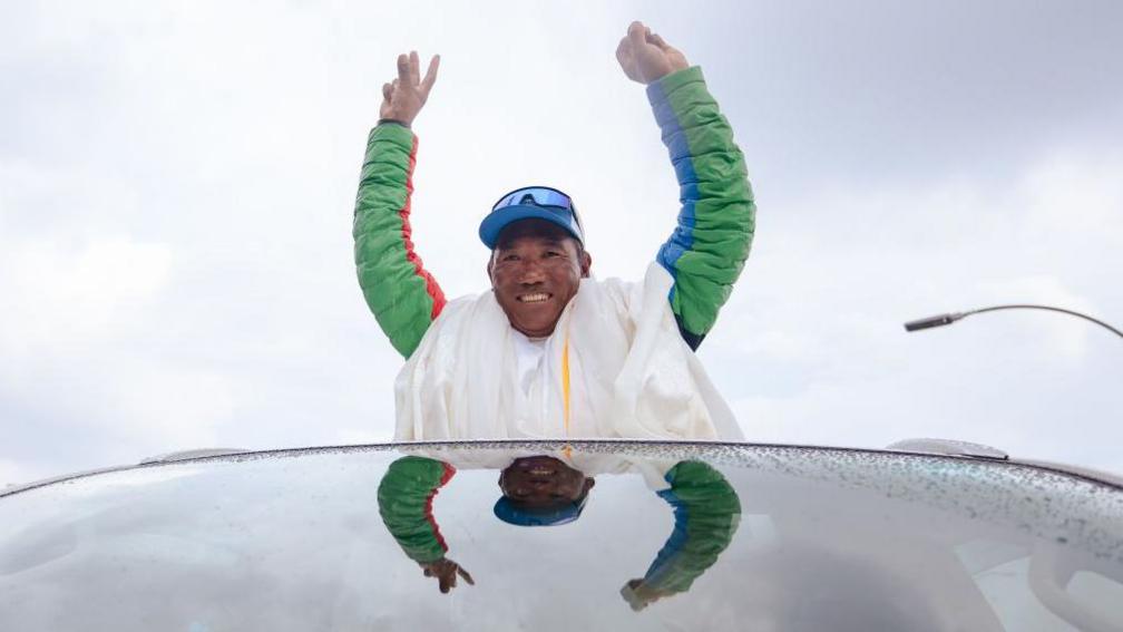 Legendary Mountaineer Kami Rita Sherpa waves at people as he arrives after scaling Mt Everest in 2024