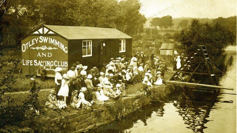 A black and white historic image of Otley Swimming and Life Saving Club on the river Wharfe