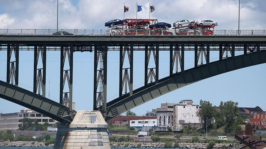 A car transporter driving across the Peace Bridge between Canada and the US