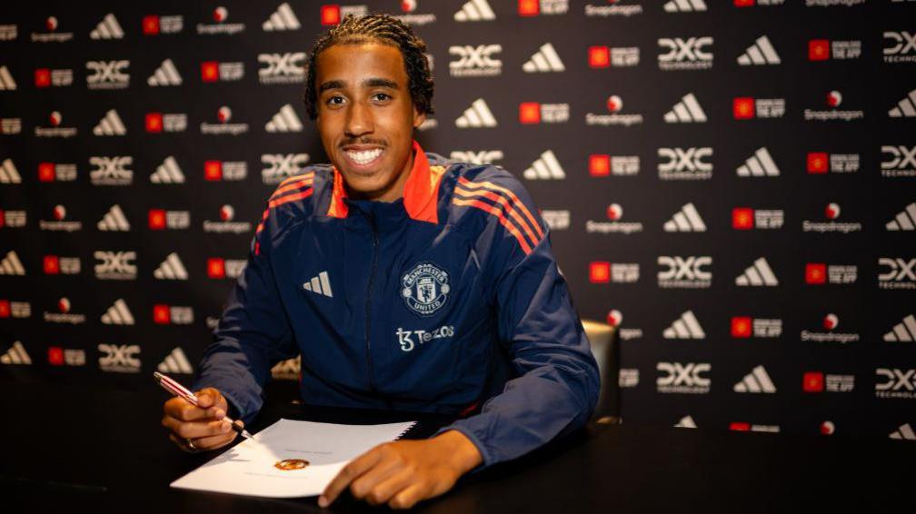 Leny Yoro poses with his Manchester United contract