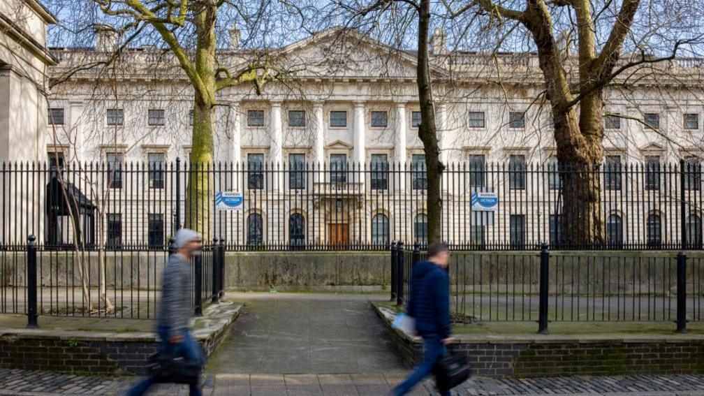 Passers-by walk past the the Royal Mint Court office complex in the City of London the possible future site of a new Chinese Embassy