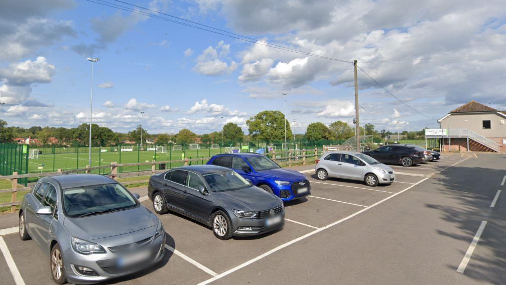 A Google Street View from the car park. Behind it are small football pitches, possibly for five-a-side. A cafe is at the bottom of the car park.