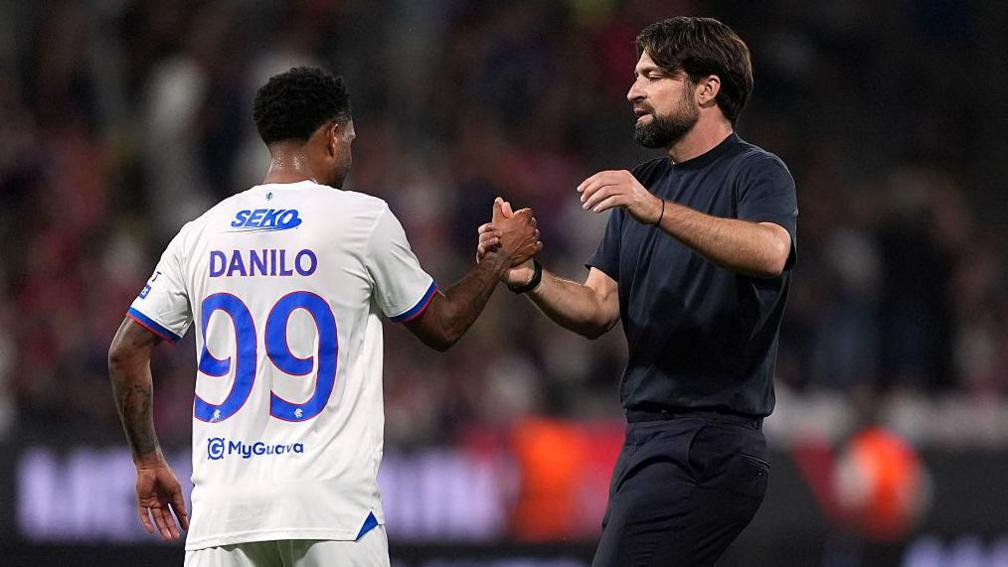 Russell Martin shakes hands with Rangers' Danilo
