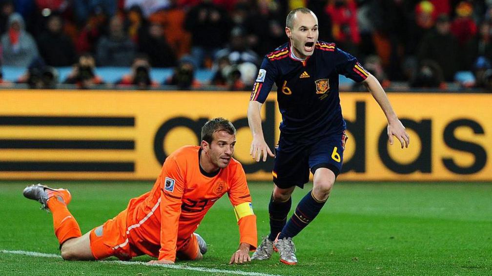 Andres Iniesta celebrates scoring for Spain while the Netherland's Rafael van der Vaart is on the ground