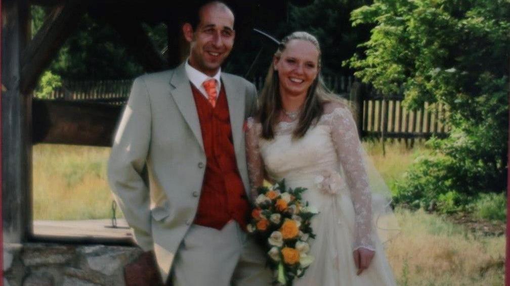 A couple standing outside on their wedding day