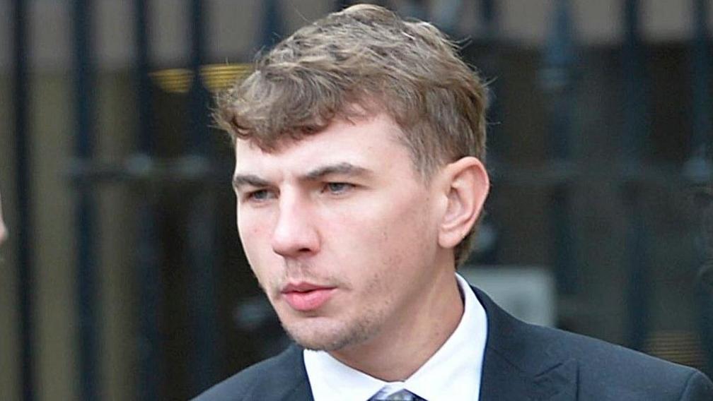 John Forsyth has short, brown hair and is wearing a suit jacket with a white shirt