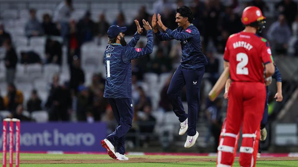 Moeen Ali and Jafer Chohar jump and high five after a Lancashire wicket