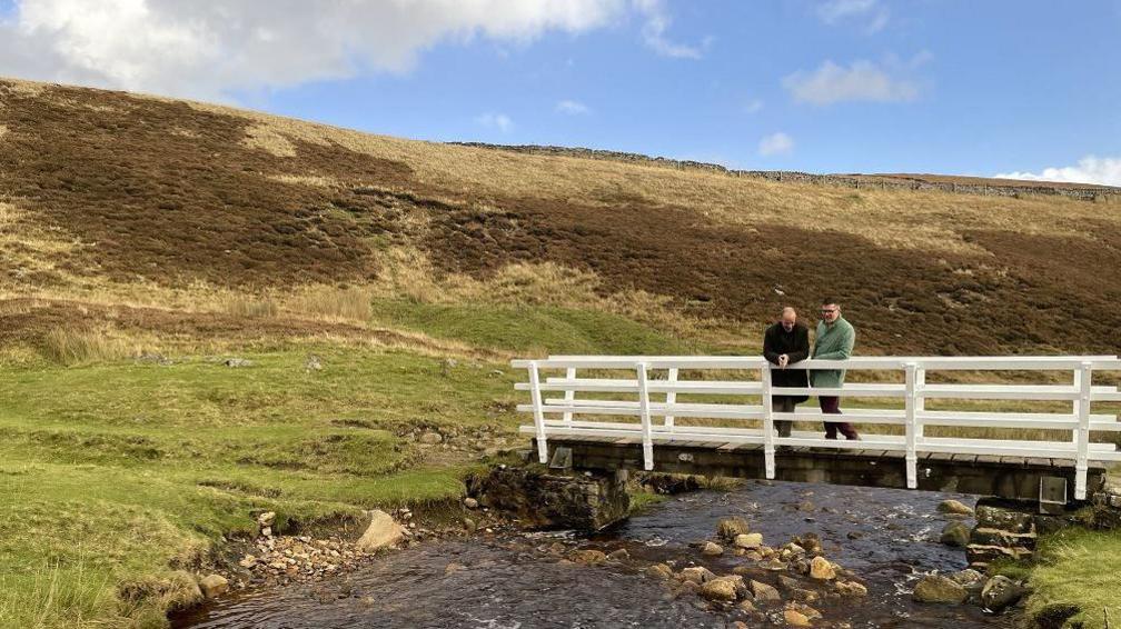 Mr Lefley and his brother standing on the bridge over a stream in the Yorkshire Dales 