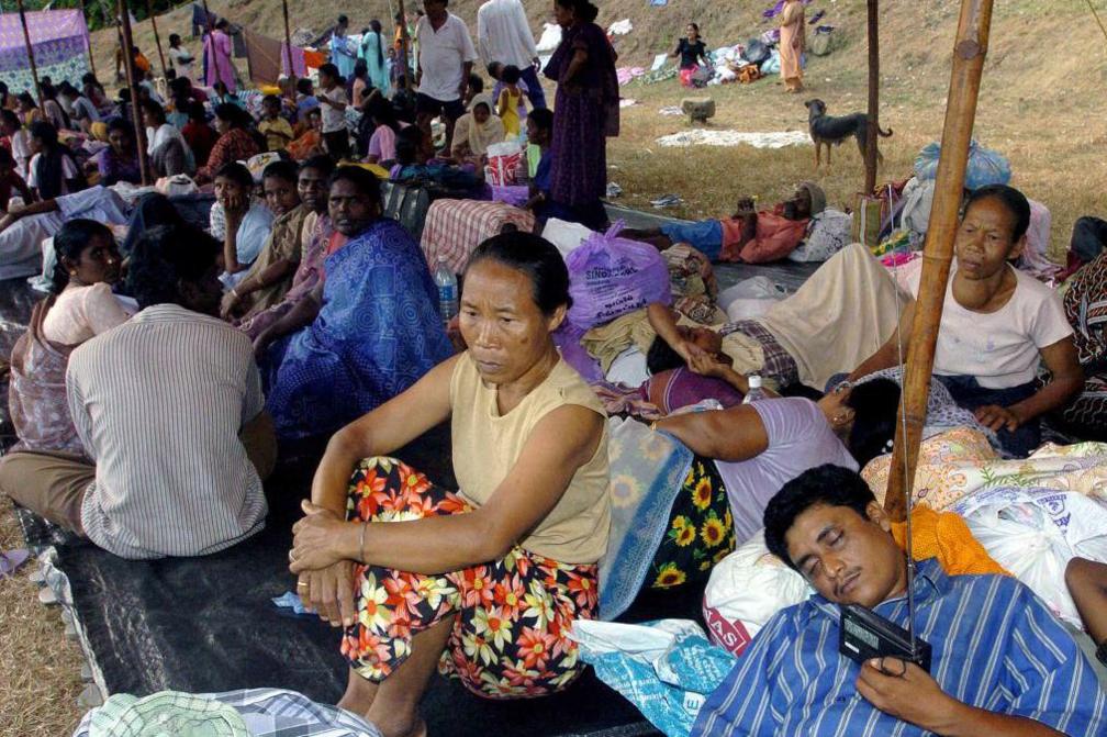 Indian villagers rest at a relief camp in the capital of India's Andaman and Nicobar Islands, Port Blair, 31 December 2004. Indian survivors of the tsunami waves are desperately trying to trace missing relatives on the Andamans islands as relief workers struggled to piece together families parted in the ordeal. 