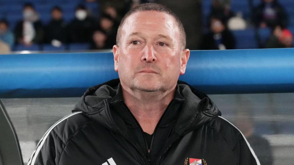 Steve Holland wearing a black coat