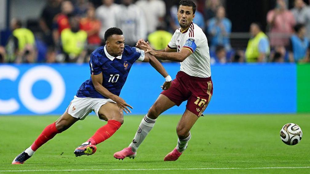 Kylian Mbappe and Rodri with the ball