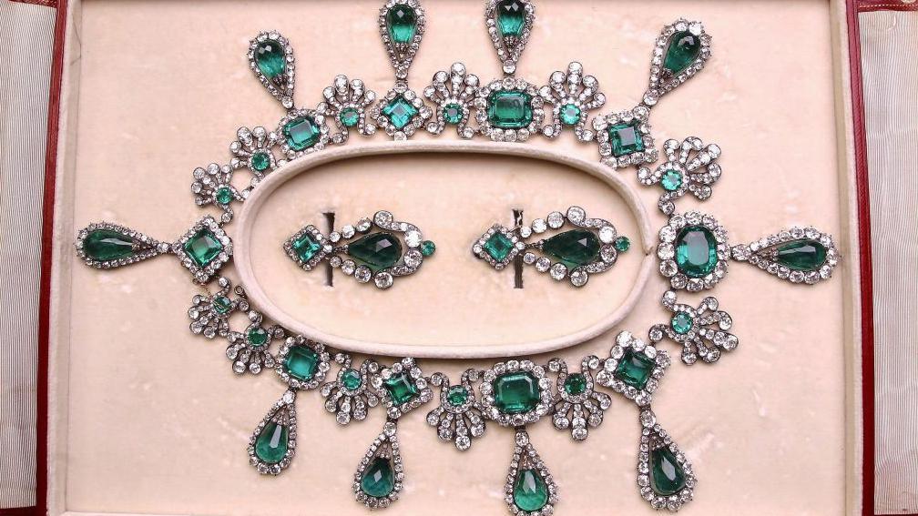 The spectacular emerald earring and necklace set laid out in a display case
