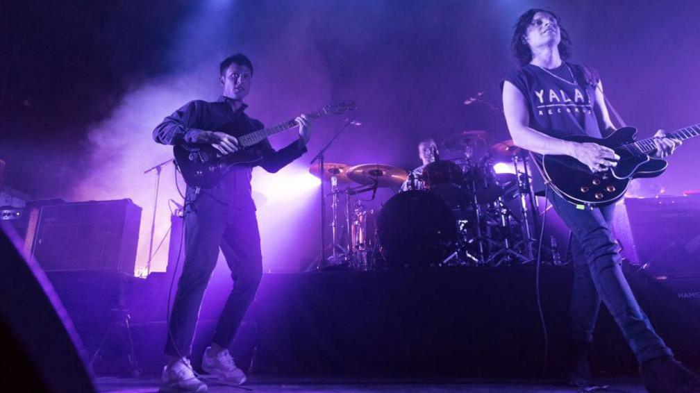 The Maccabees mid-song on stage.